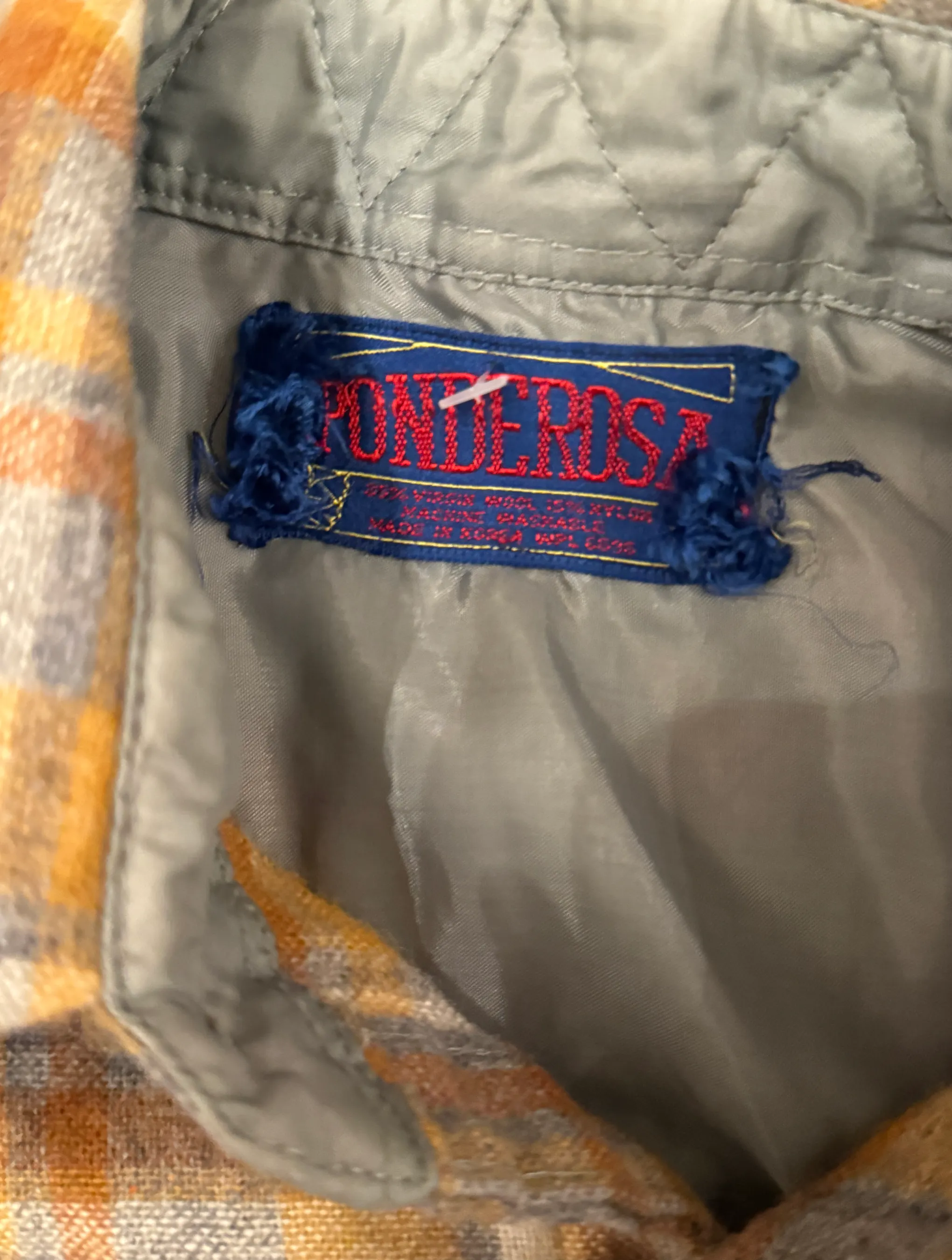 Close-up of a 'Ponderosa' label on a quilted fabric surface.